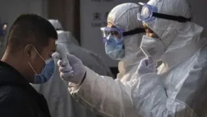 a_chinese_health_worker_checks_the_temperature_of_a_woman_entering_a_subway_station_during_the_chine_1582078124